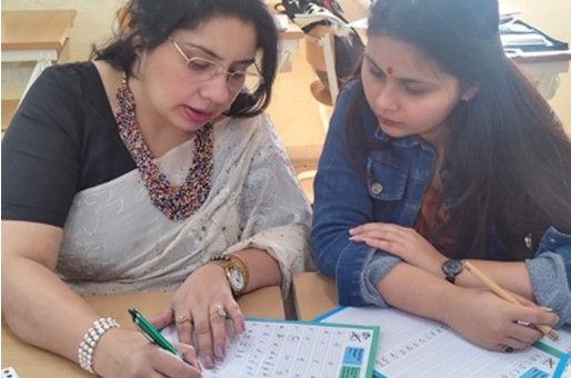 Trainer guiding a teacher one-on-one during a handwriting workshop