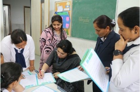 Trainer reviewing handwriting practice with participants